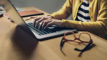 Working from Home Late at Night: Hands of an Anonymous Woman Sitting in her Home Office and Using her Laptop Computer